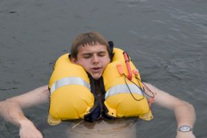 A properly inflated PFD keeps the sailor's head above the water. Notice the deflate valve is easily accessible on the left panel. 