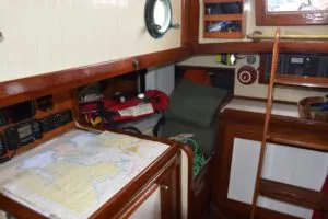 The nav station hides a fold-out leaf that creates extra counter space when needed. The quarter berth, as is often the case with single-hander sailors in tight quarters, is a storage space. (Photo/ Bert Vermeer)