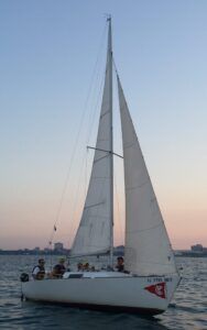 Sailors on this J-22 fly the jib at sunset. Jibs allow boats to point closer to the wind. (Photo/ Nick Van Antwerp)