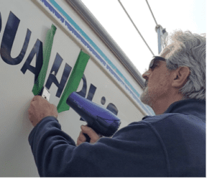 The heat from a hairdryer melts the adhesive under the vinyl and allows you to free the letter from the hull with the scraper. (Photo/ Marc Robic)