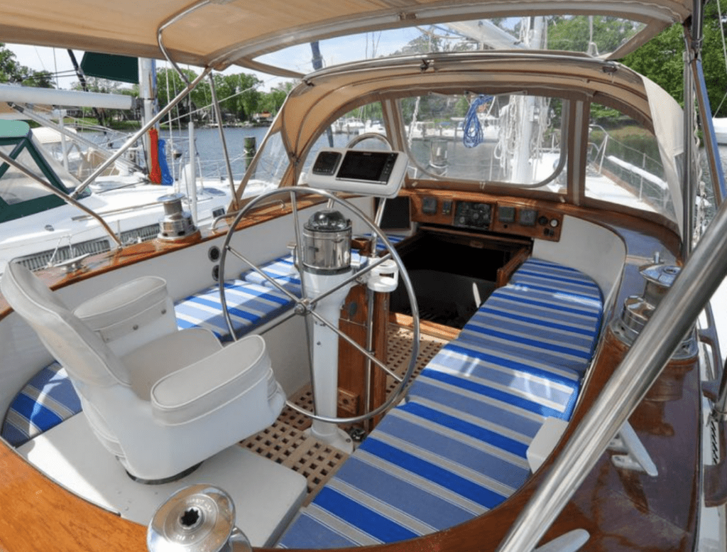 Gorgeous brightwork surrounds this comfortable, spacious center cockpit. Crew and captain are protected from the weather via the bimini and dodger, without sacrificing visibility. Photo courtesy of YachtWorld.