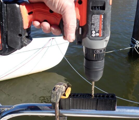 A V-Guide in use on stainless pulpit railing. V-Guides keep your drill bit from walking off either side of the curved surface. They are a helpful tool in this scenario since stainless requires steady, slow, lubricated pressure to drill properly.