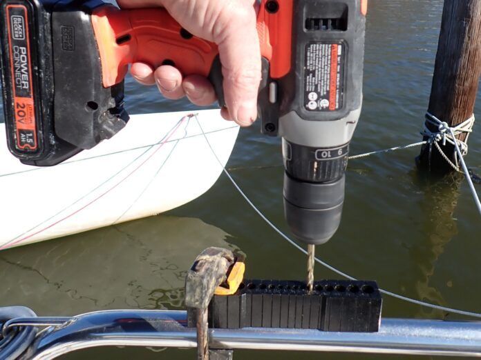 A V-Guide in use on stainless pulpit railing. V-Guides keep your drill bit from walking off either side of the curved surface. They are a helpful tool in this scenario since stainless requires steady, slow, lubricated pressure to drill properly.