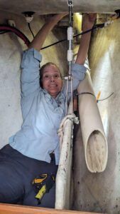 The author in the anchor locker of a new-to-them Island Packet 40. Lifting a 15-pound motor above your head in a cramped space is boat-bite territory. (Photo/ Alison O'Leary)