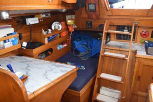 While the 1960s nav station has enough room for paper charts, modern electronics are installed outside in the cockpit for the helmsperson. The quarter berth takes full advantage of that extended stern and is a roomy, yet cozy, sleeping spot. Or for offshore cruisers, it's a inevitable storage space that is so long, it is best to write a list of what you put back there. (Photo/ Bert Vermeer)