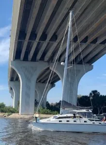 No matter how high the bridge is, it never seems high enough. We have over 15 feet of clearance here (captured by a friend on shore). Note my mainsail is still wrapped and has been for several hundred miles. (Photo/ Alex Jasper)