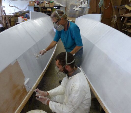 "The epoxy primer was applied quickly by Jacob and Hanneke, one rolls it on the other strokes it out. We applied two coats and afterwards wet-and-dry sanded them." (Info/Photo Wharram Designs)